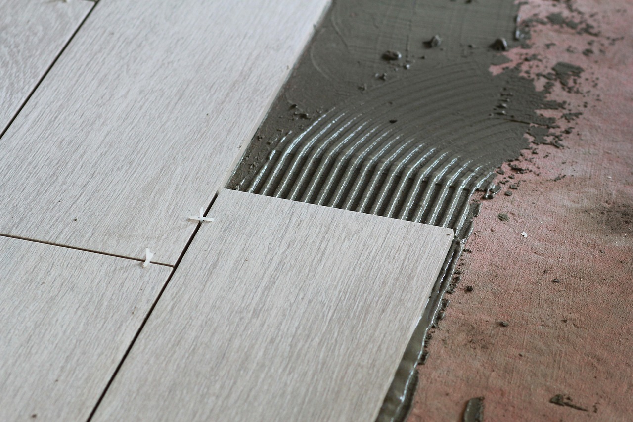 New porcelain tile floor being laid in a bathroom