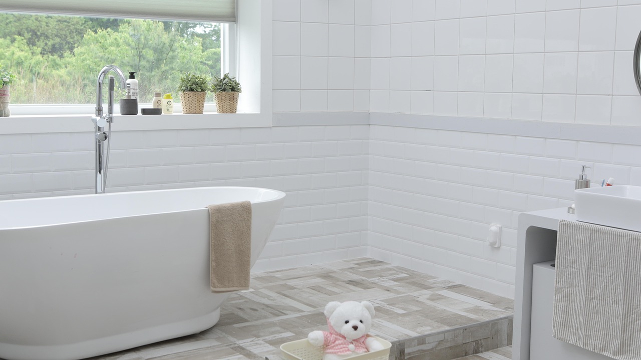 Bright bathroom with a white tub and tiled walls